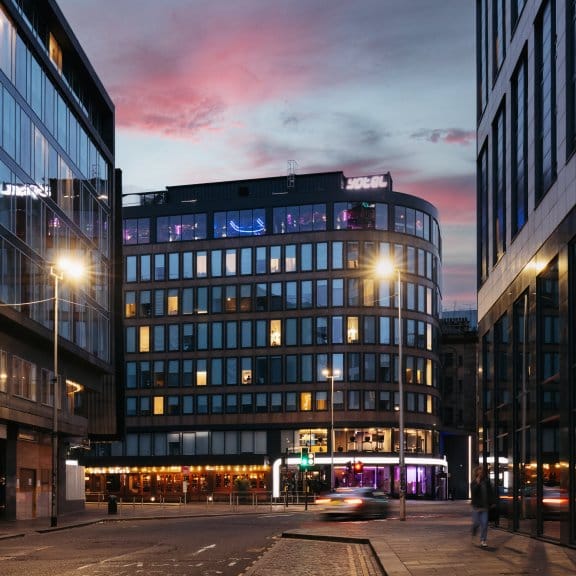 Exterior view of a modern glass building at dusk 