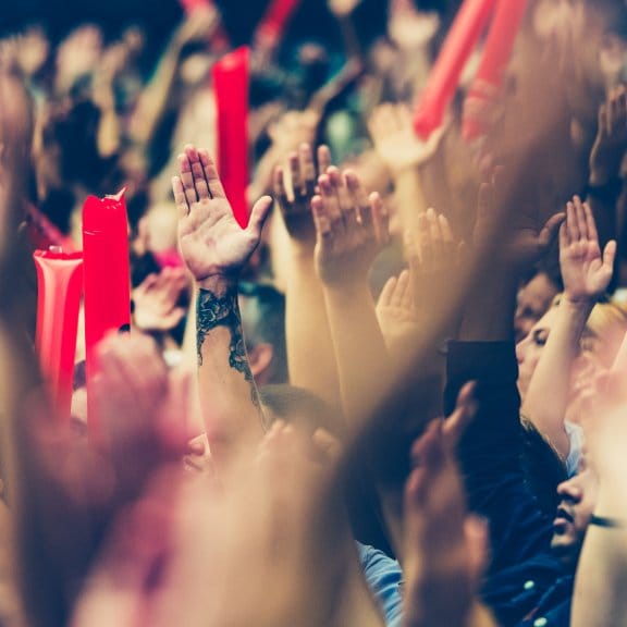 Football fans cheer on a game in a large stadium