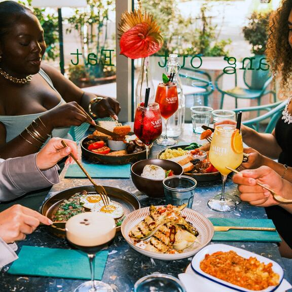 A group of friends eat and drink in a hotel restaurant