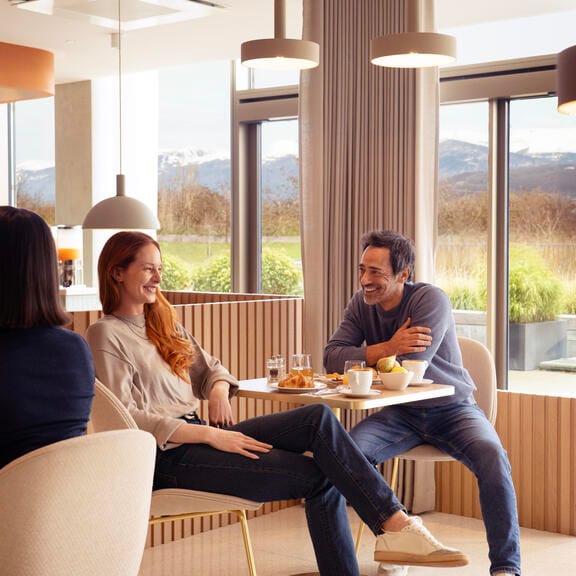 Couple laughing and enjoying breakfast with Alpine mountain views in the background