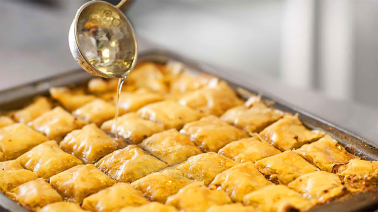 Baklava with syrup being poured over
