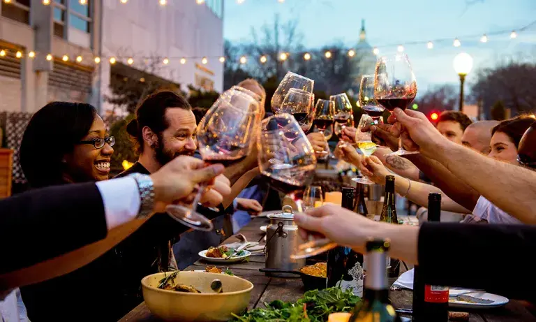 YOTEL Washington DC terrace - People raising glasses over a dinner table