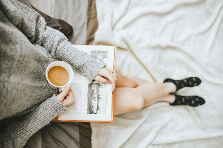 woman reading a book with a cup of coffee
