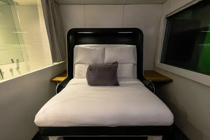 A large bed with clean, white sheets located in an airport hotel