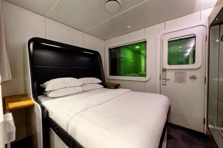 A large bed with clean, white sheets located in an airport hotel