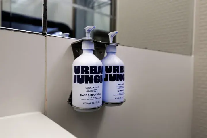 Urban Jungle hand soap hangs on the wall by a bathroom sink