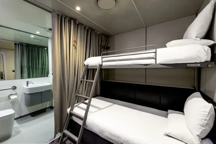 Twin bunks in a smart but compact hotel room with its own bathroom