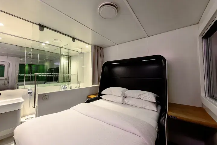 A large bed with clean, white sheets located in an airport hotel