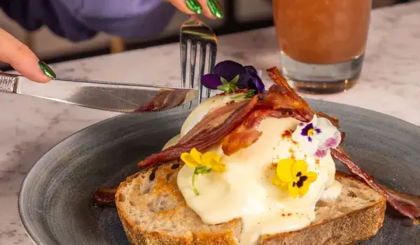 woman cutting into breakfast food