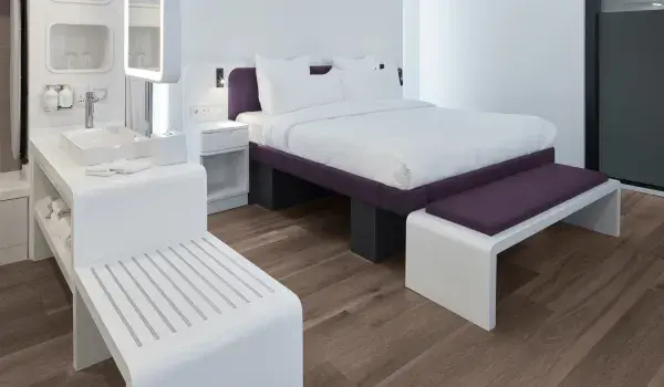 Junir Suite King Size Bed with a end bench, sink & mirror and a luggage stand shown 