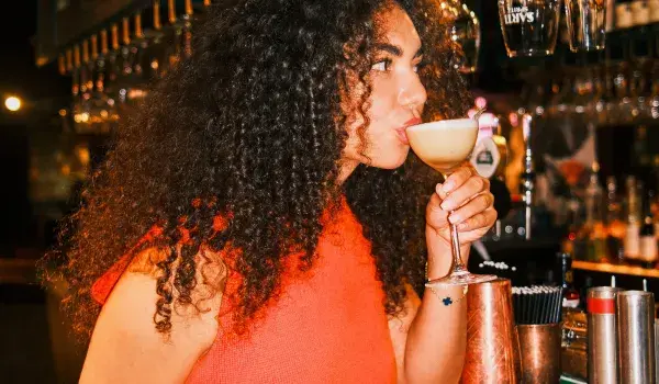 Woman drinking cocktail at a bar