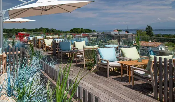 landscape of view of roof terrace with chairs and an open parasol