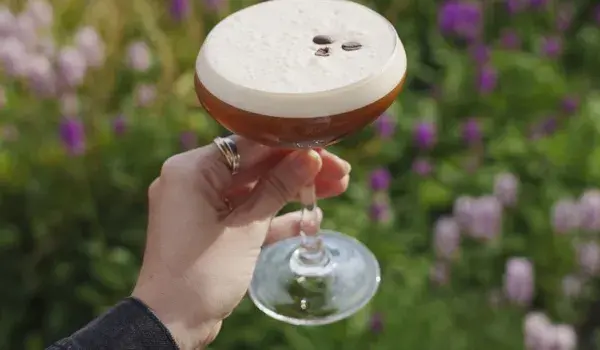 Womans hand holding espresso martini cocktail