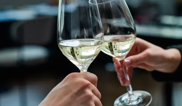 Two wine glasses clinking