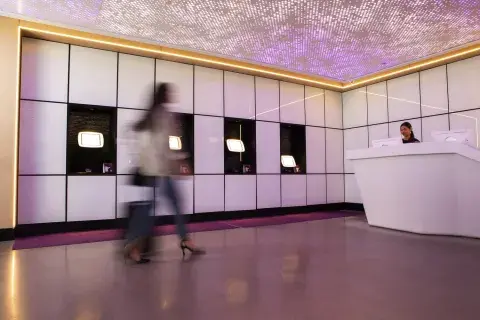 Blurry woman strolls through a hotel lobby with her suitcase