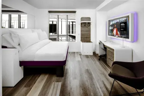 A large hotel suite with purple accents and big windows