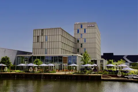 YOTEL Amsterdam exterior, showing the canal, deck waterside and building