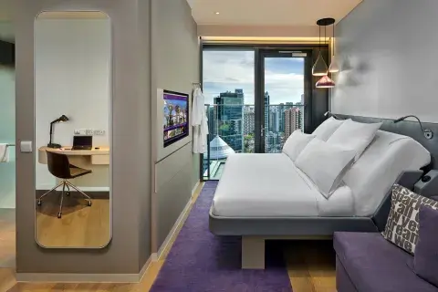 Hotel room with a large mirror, SmartBed and floor-to-ceiling windows with views of Singapore