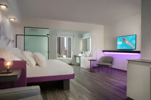Large hotel room with a flatscreen TV, large bed and mood lighting