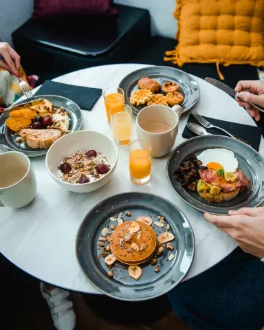 A breakfast spread with pancakes, muesli and orange juice