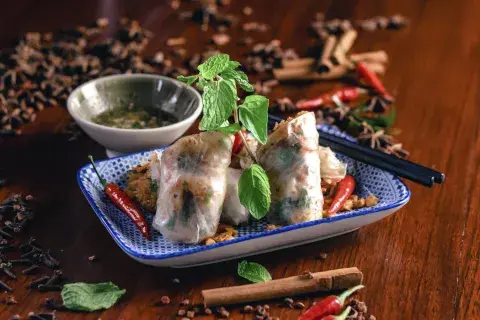 Hot food on a table surrounded by an array of fresh dips and spices