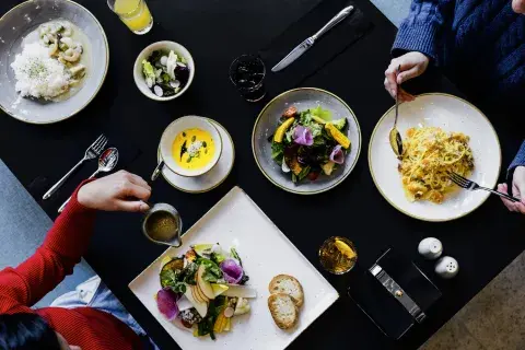 Three friends tuck into a platter of dinner served at a restaurant and bar