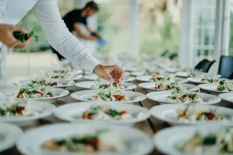 Plates of food being plated up before a large event